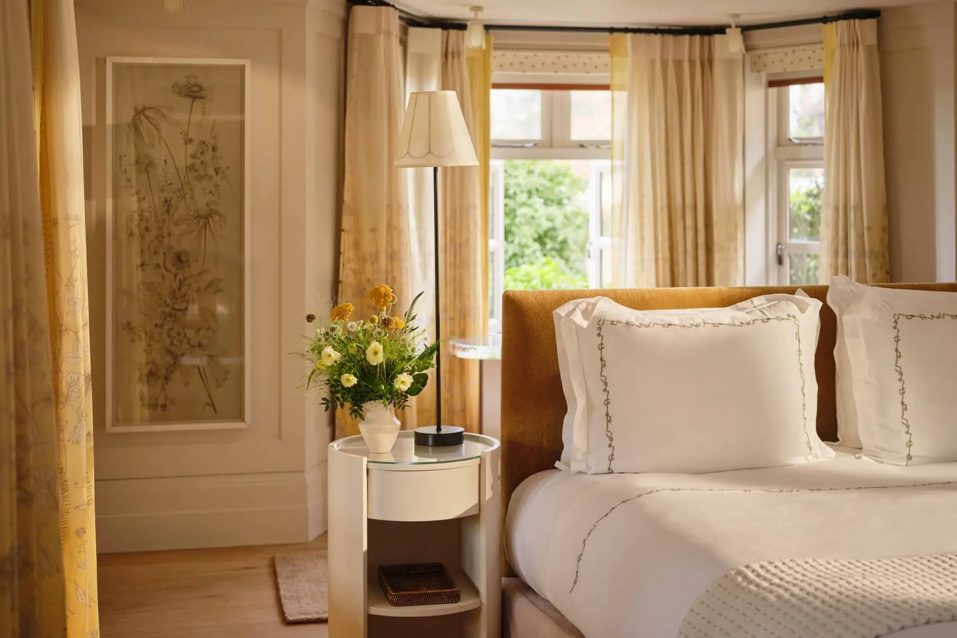 Luxury bedroom with neatly styled bed, bedside table, and soft curtains in a warm, cinematic setting
