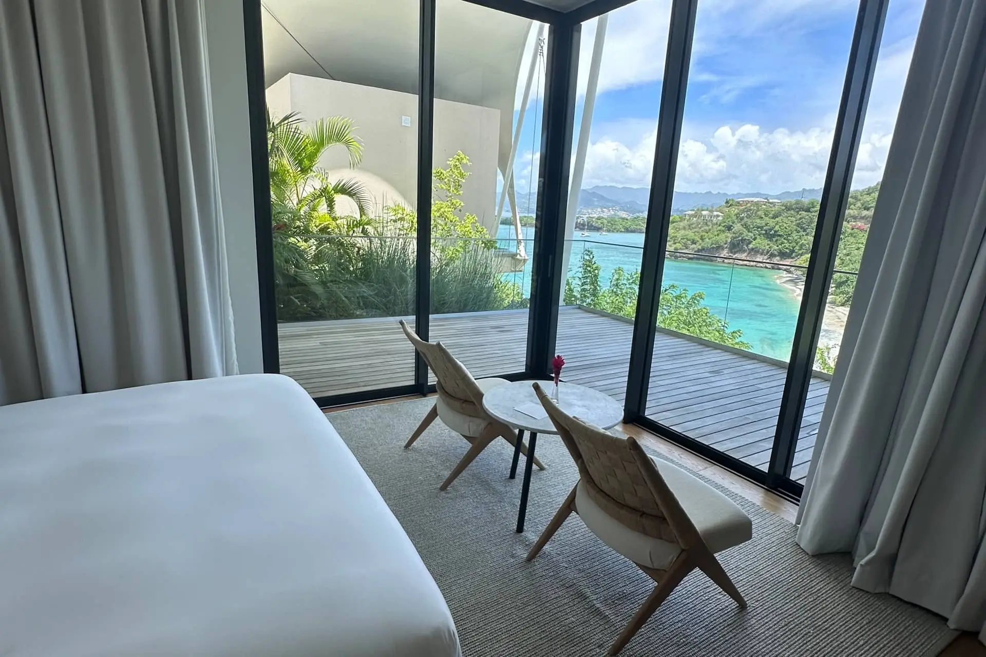 Luxury balcony lounge with chairs and ocean view over a turquoise shoreline