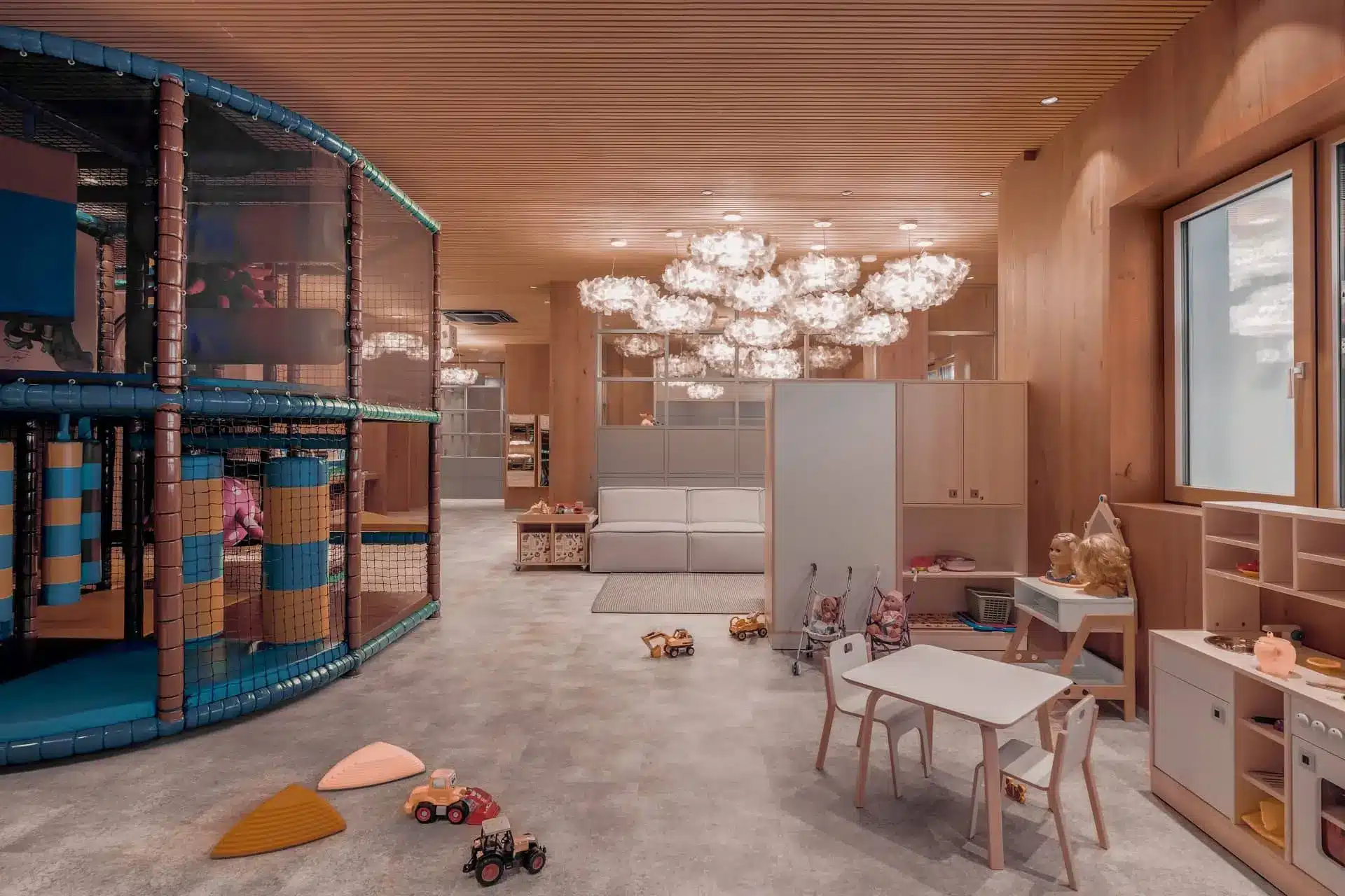Elegant children’s playroom with indoor climbing structure, toys, and soft seating in a luxury setting