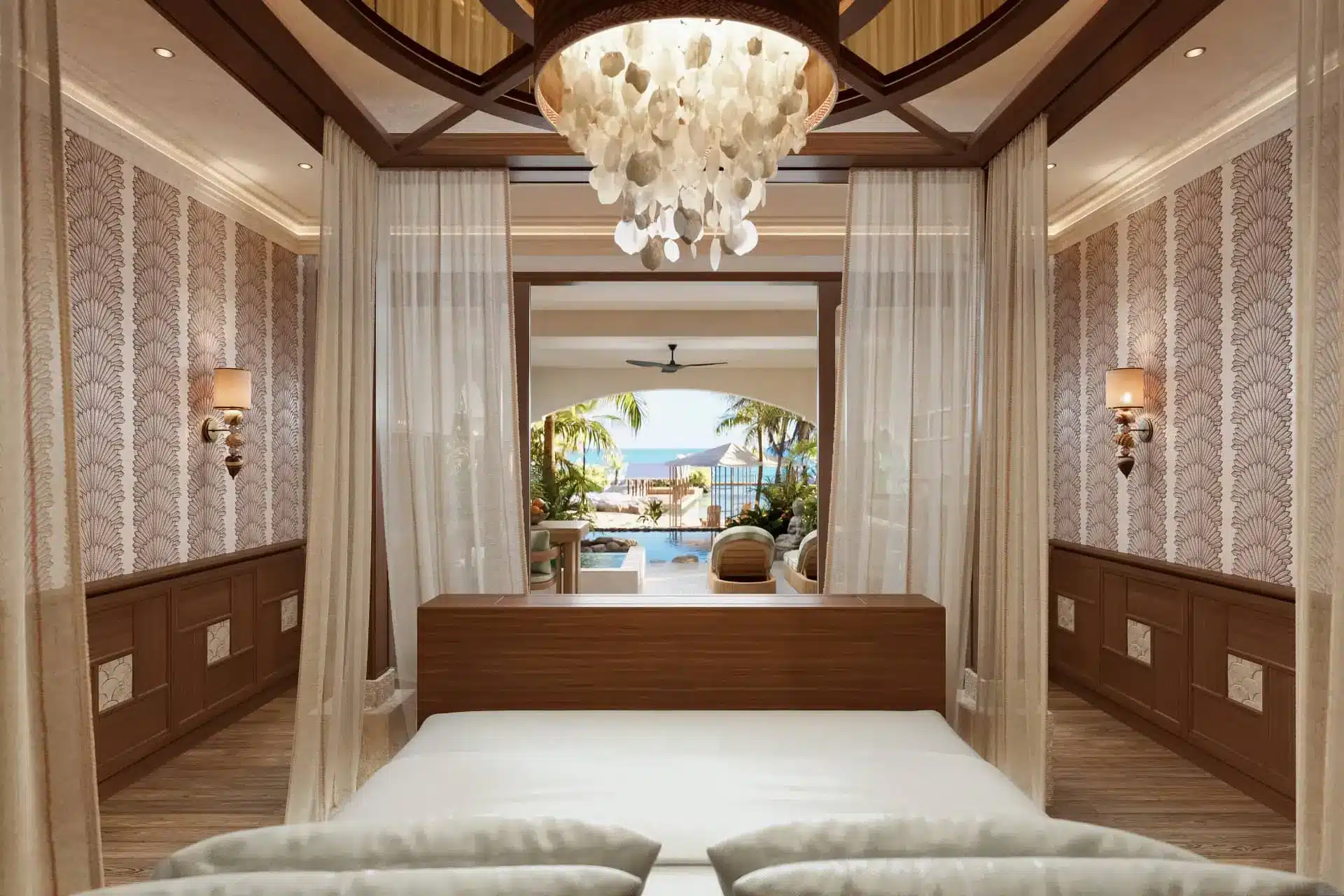 Luxury bedroom with canopy curtains, chandelier light, and ocean-view terrace beyond