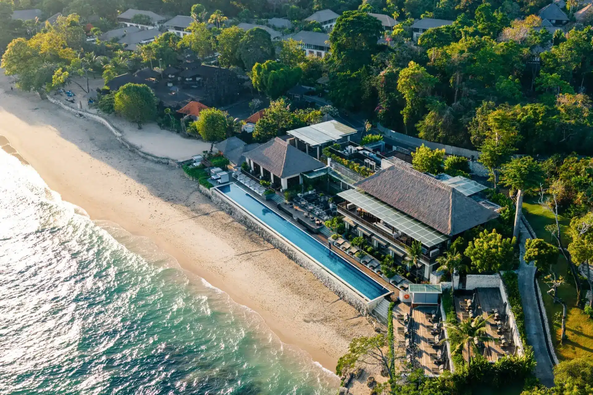 Aerial view of Four Seasons Resort Bali’s beachfront villas, pool and gardens beside Jimbaran Bay