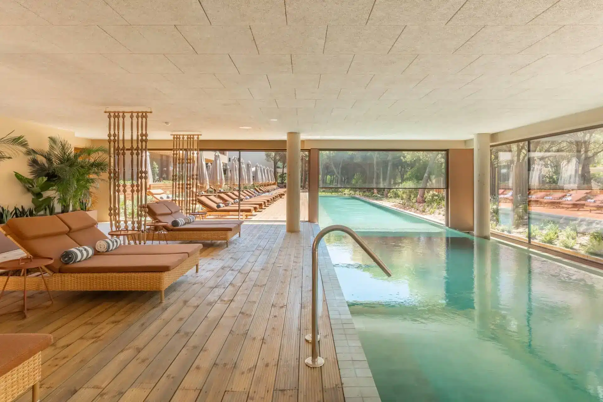Luxury indoor pool with loungers and tropical views at a high-end wellness resort