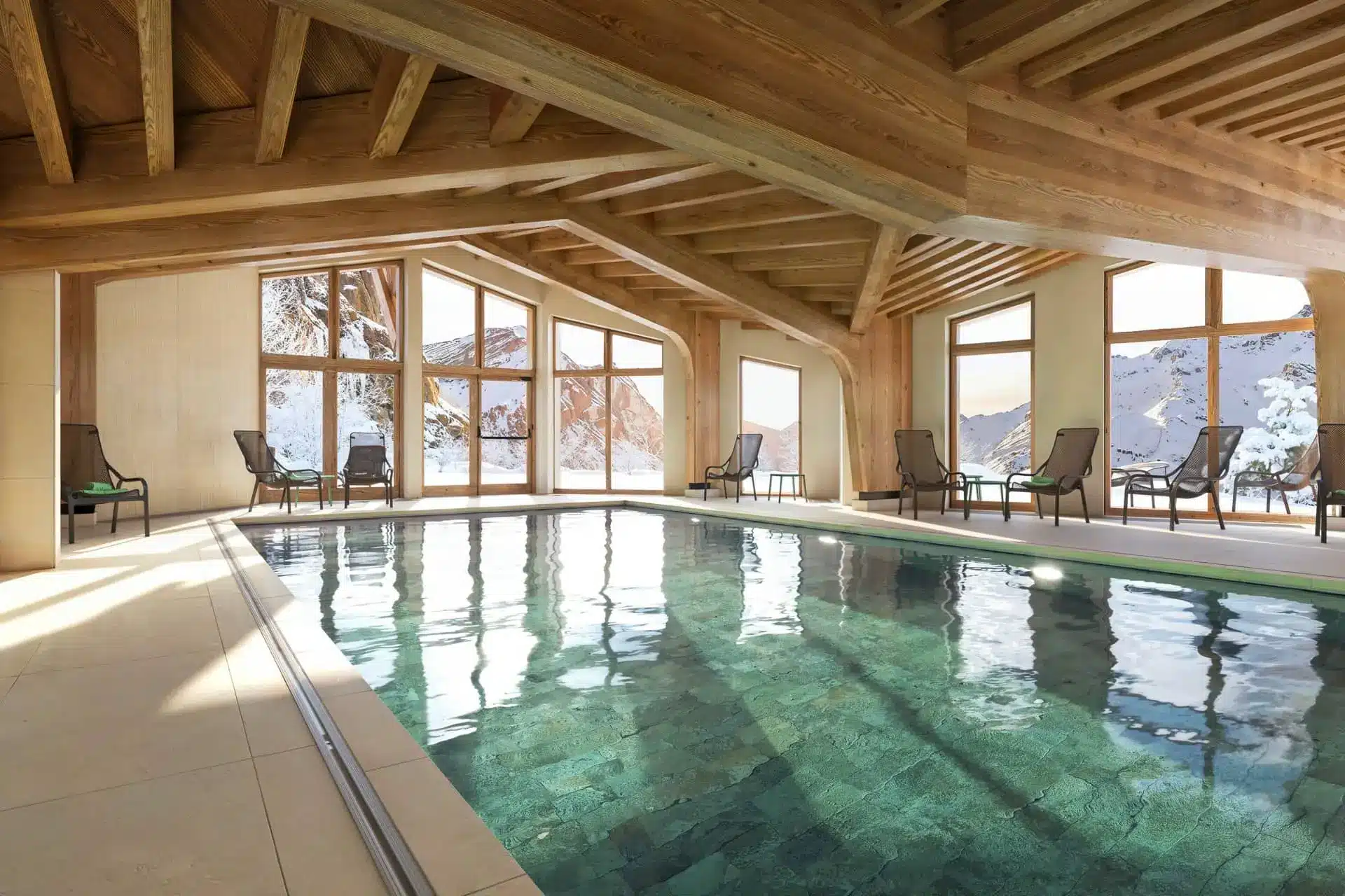 Indoor swimming pool with mountain views and timber beams at Residence Capella in Avoriaz