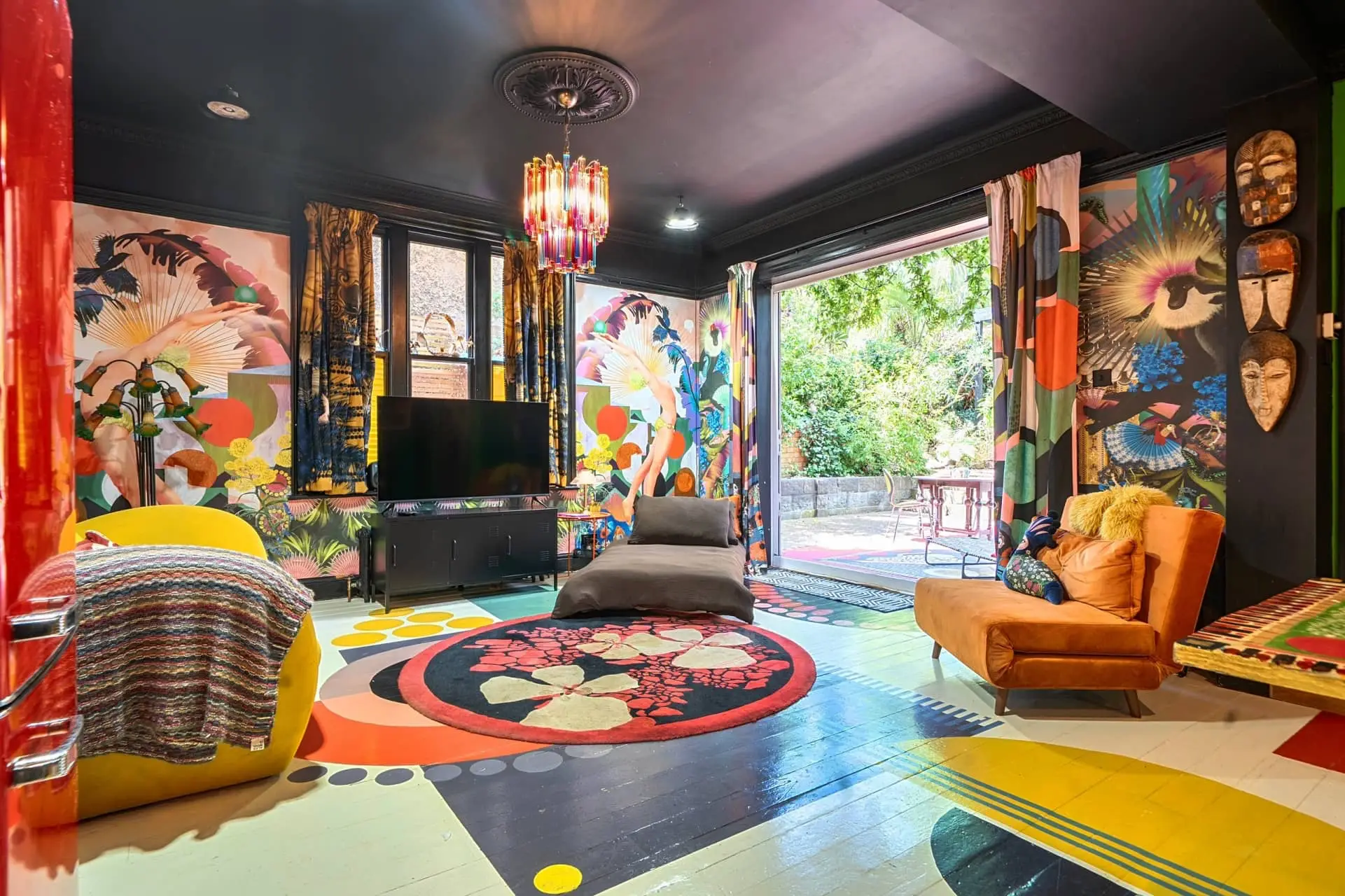 Colorful eclectic villa living room opening onto a lush garden terrace