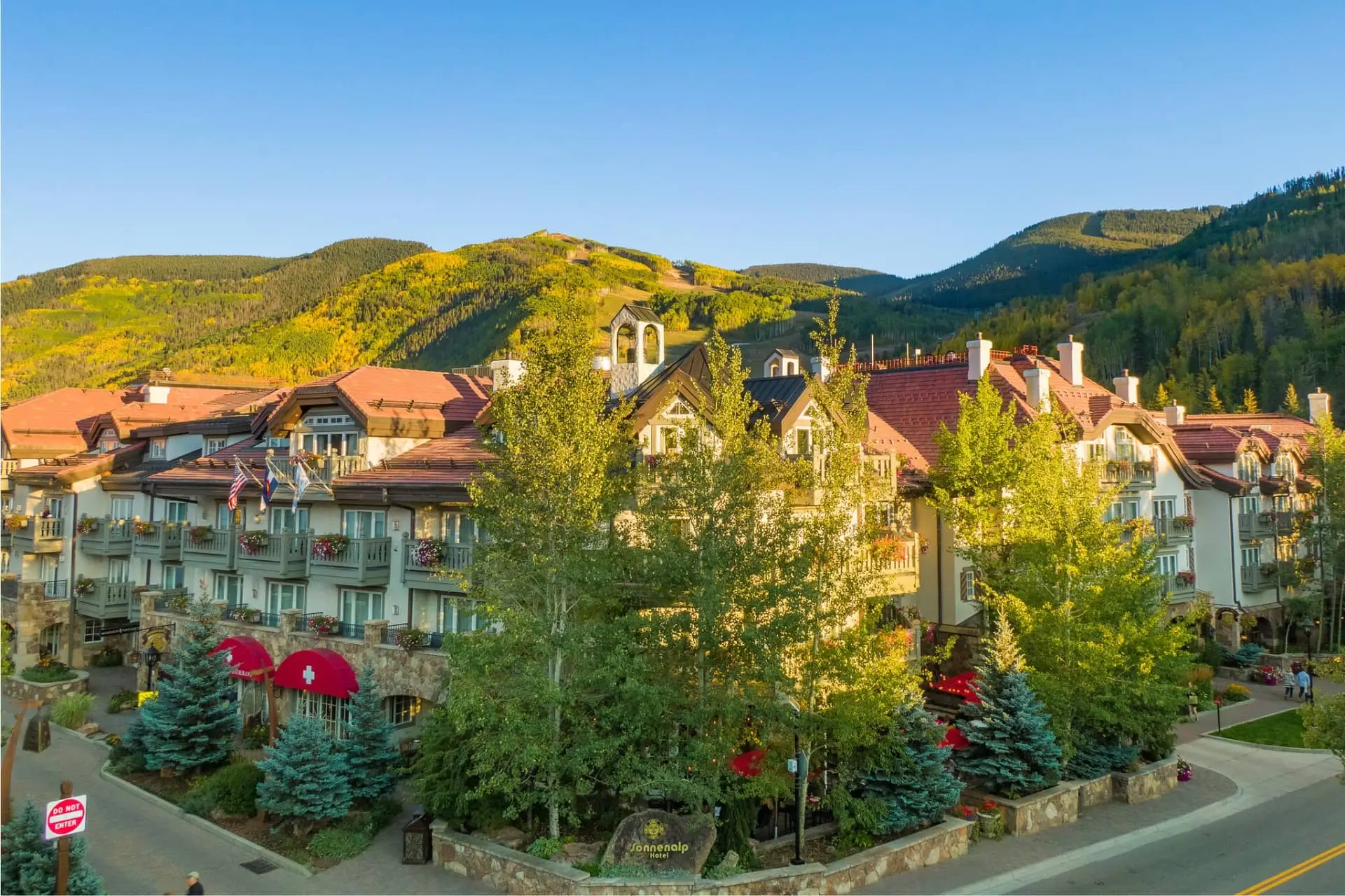 Luxury alpine resort village surrounded by forested hills and autumn foliage