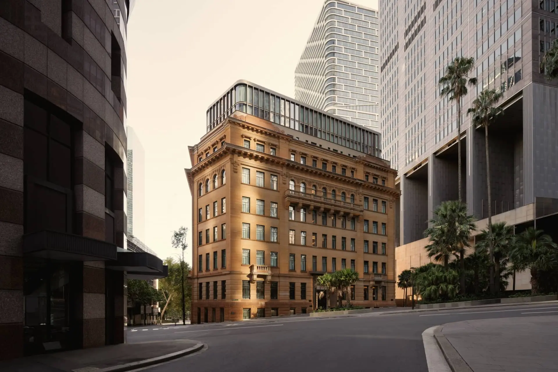 Capella Sydney’s restored sandstone hotel building on a city street, framed by modern high-rises