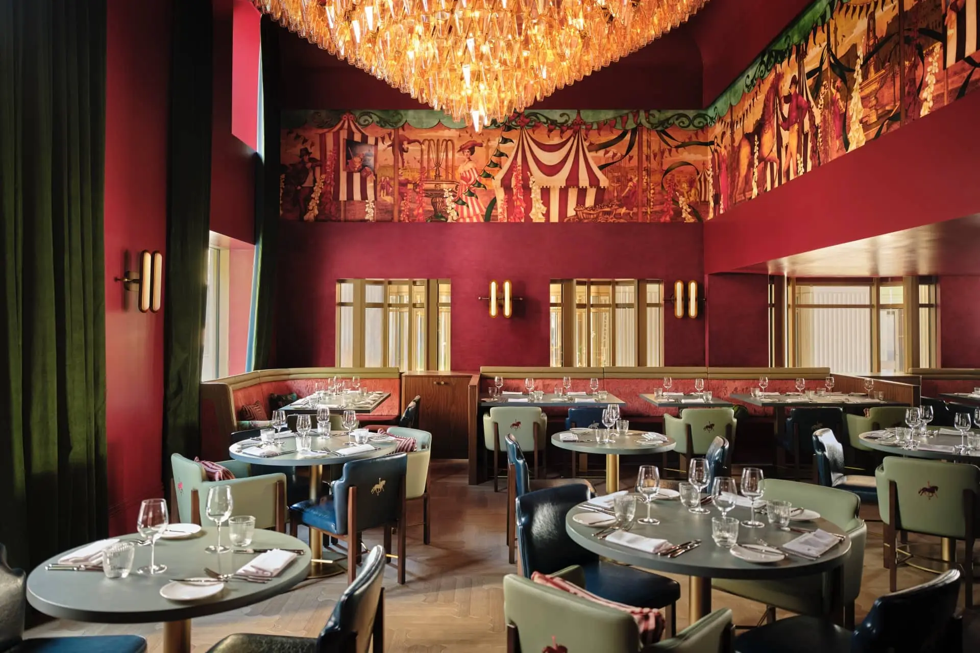 Atmospheric luxury restaurant dining room with a grand chandelier, murals, and elegantly set tables