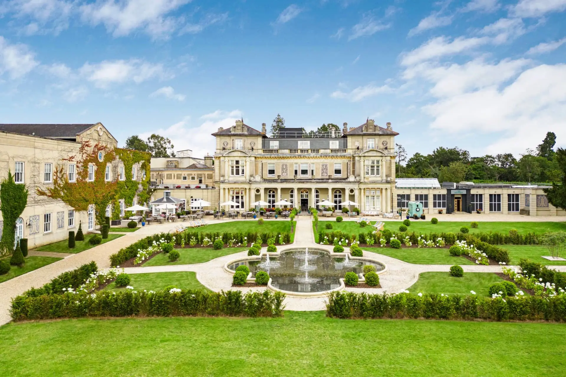 Grand luxury country house with formal gardens, fountain and manicured lawns