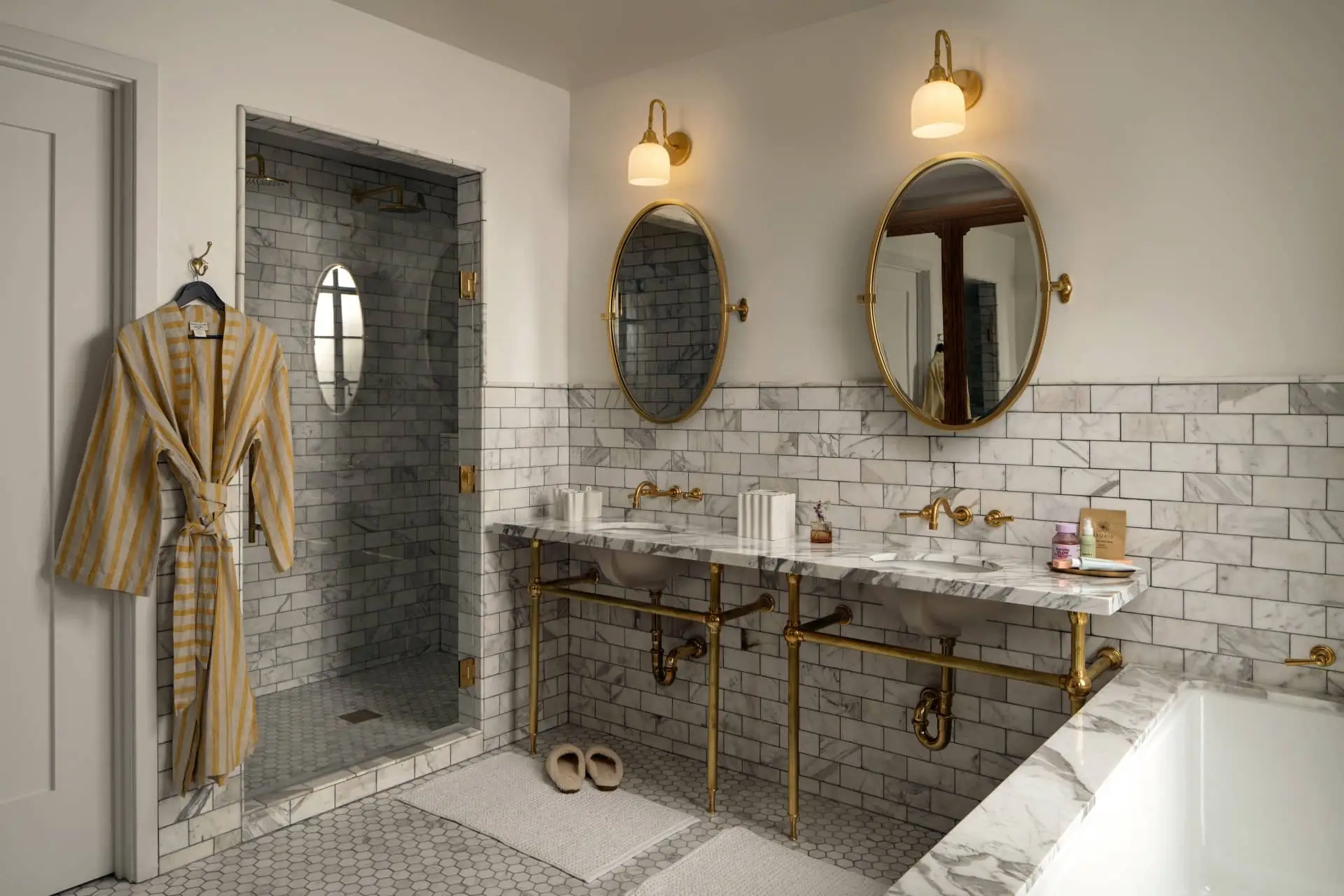 Hotel Lucile bathroom with a double vanity, tiled walls, brass fixtures and a stained-glass window