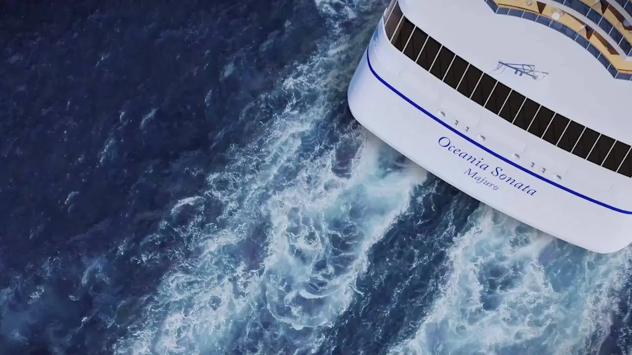 Aerial view of a luxury yacht cruising through deep blue ocean water