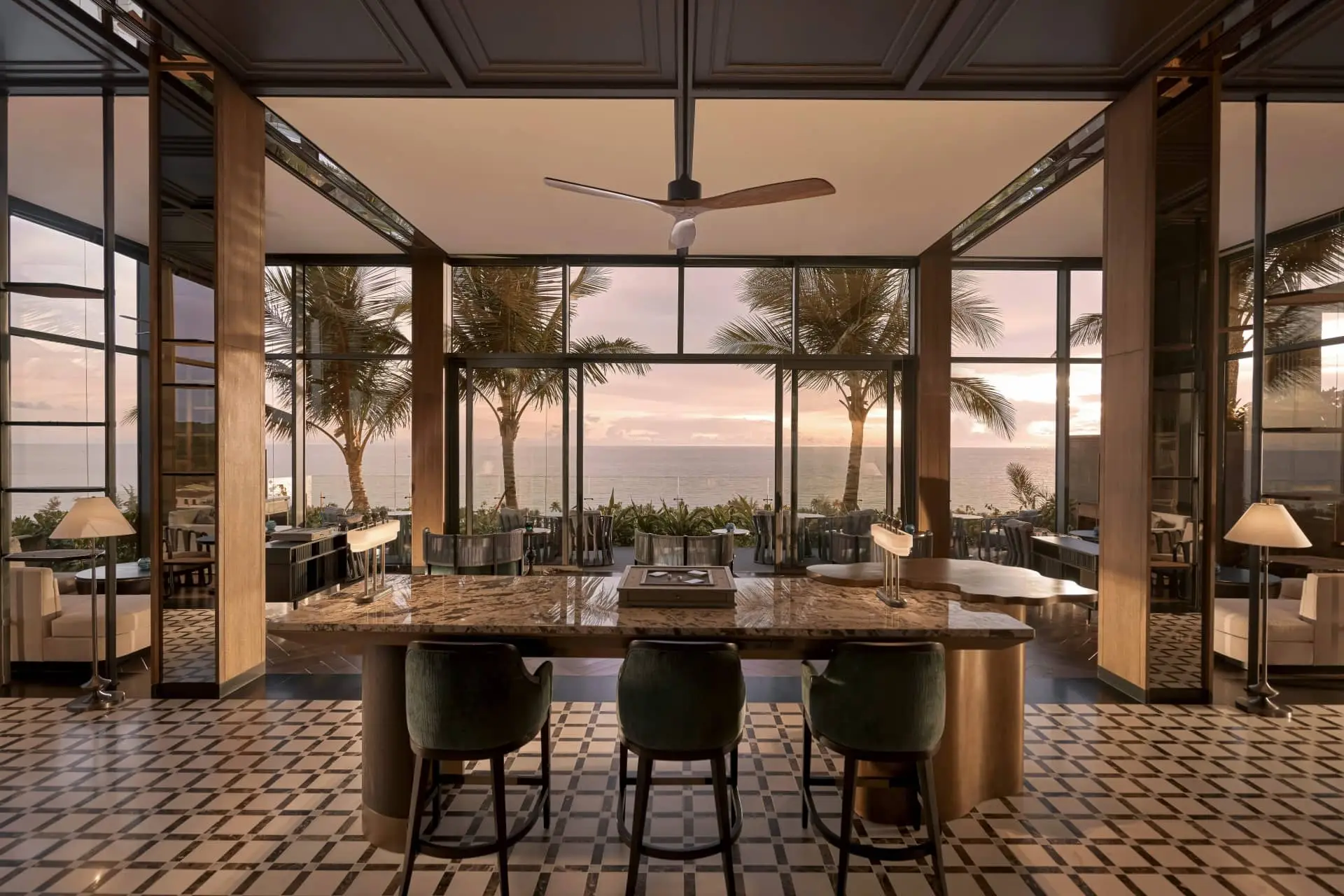 Luxury open-plan kitchen with panoramic ocean views, palm trees and a pink sunset