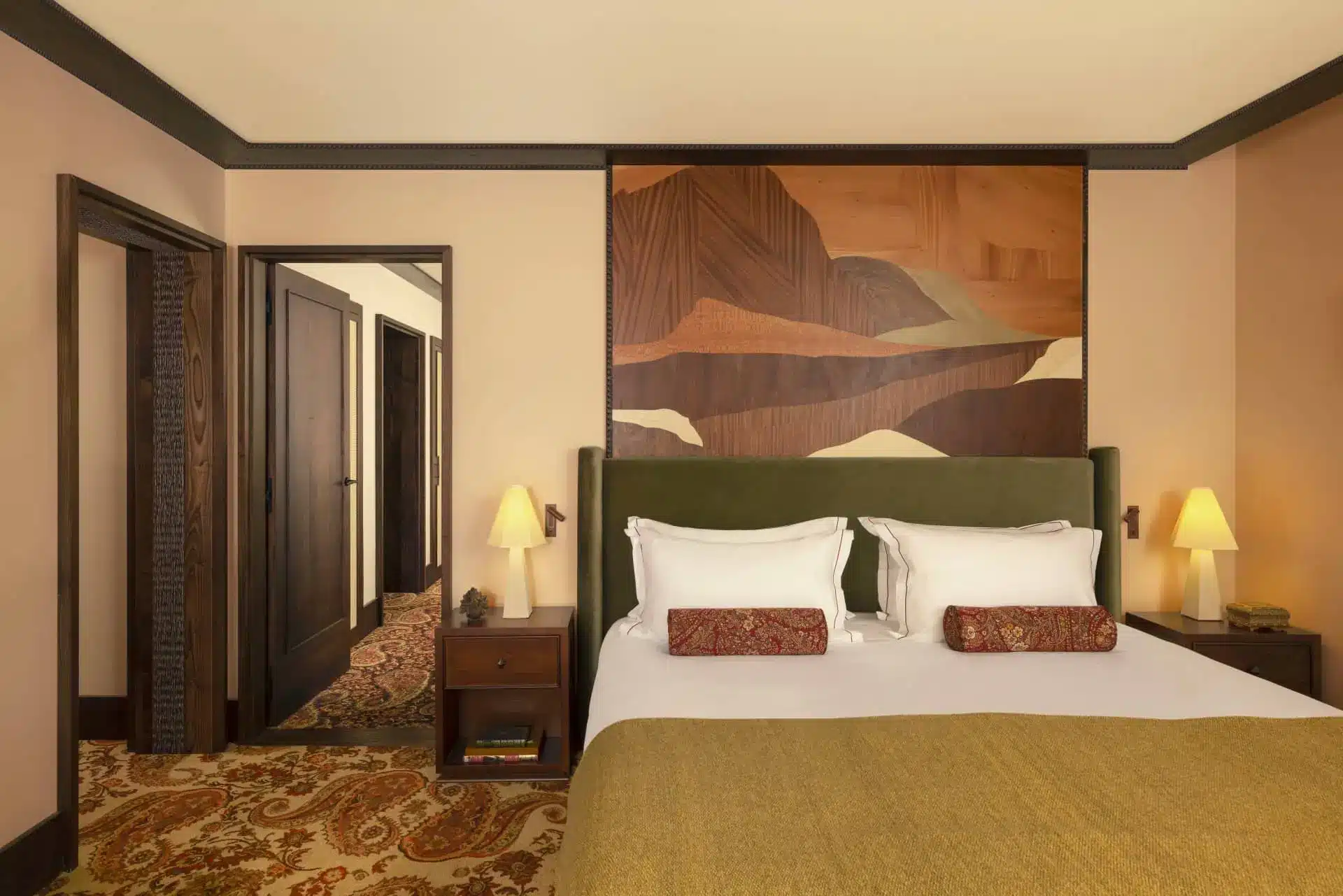 Illustrated luxury hotel bedroom with a king bed, bedside lamps, and warm-toned abstract artwork